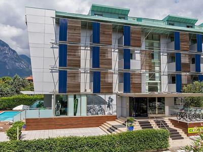 Moderno edificio dell'hotel con facciata in legno davanti alle montagne e piscina.