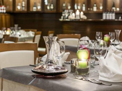 Tavolo elegantemente apparecchiato in un ristorante elegante con luce di candela e bicchieri da vino.