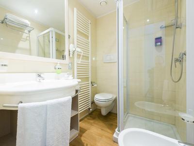 Bagno moderno con doccia, lavabo, WC e portasciugamani.