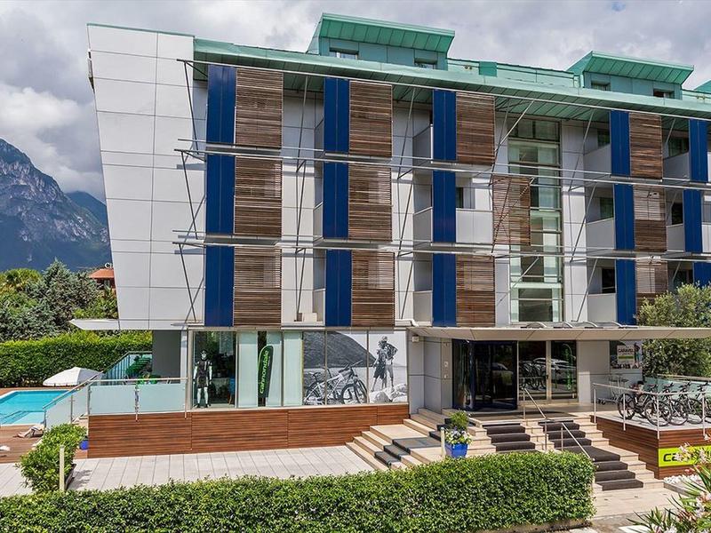 Moderno edificio dell'hotel con facciata in legno davanti alle montagne e piscina.
