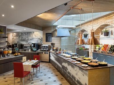 Modernes Frühstücksbuffet in elegantem Hotel mit warmem Licht und vielseitigen Speisen.