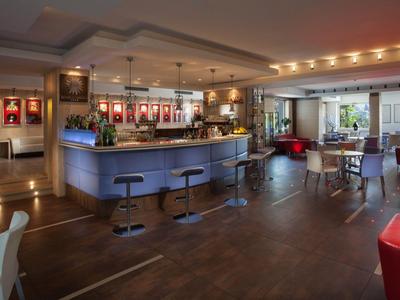 Moderner Hotelbarenbereich mit Sitzgelegenheiten, Barhockern und warmem Licht.