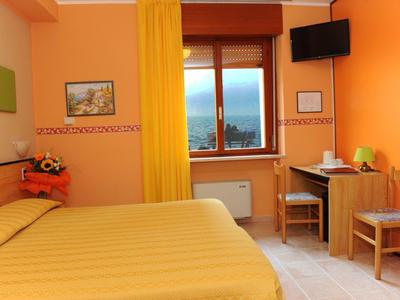 Cozy hotel room with yellow bed, curtain, and desk by the window.