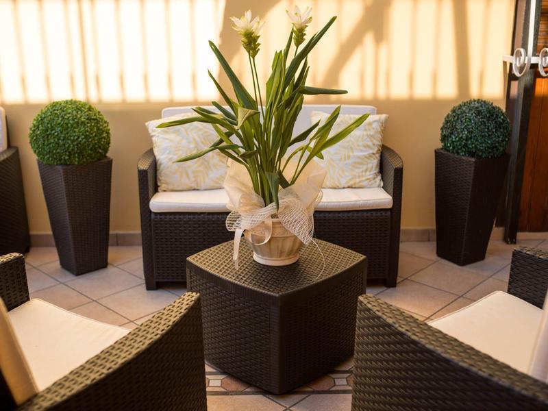 Cozy lounge area with cushioned furniture, green plants, and natural light.