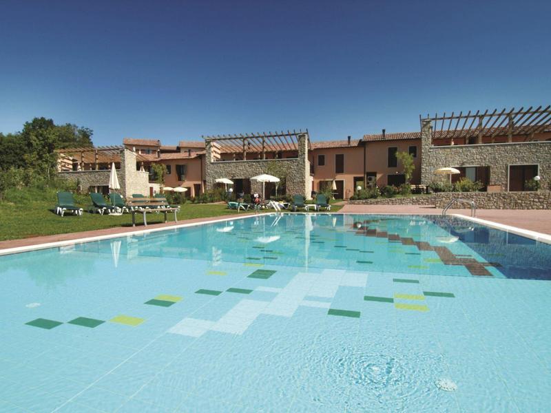 Modern hotel complex with outdoor pool under clear blue sky