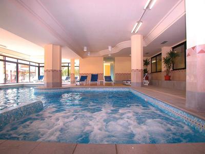 Wnętrze hotelu z jacuzzi i basenem, relaksująca atmosfera.