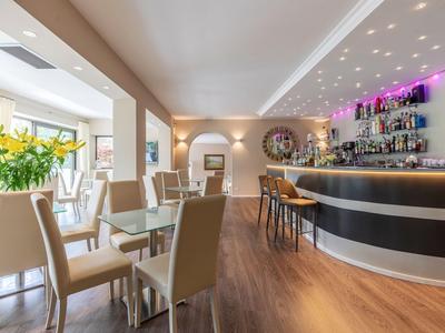 Ristorante d'hotel moderno con bar, sedie comode e atmosfera chiara e accogliente.