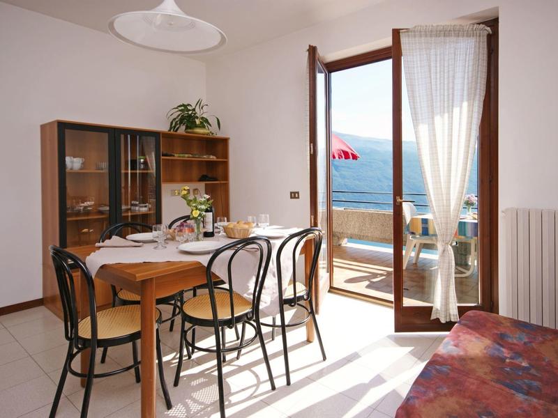 Helles Esszimmer mit Holz- und Metallstühlen, offenem Balkon und Blick auf das Meer.