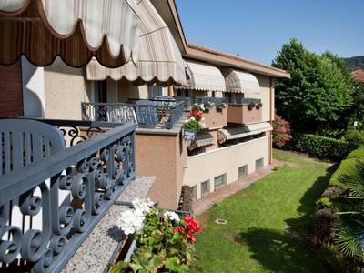 Dom z tarasem, markizami i kwiatami, zadbany ogród w słońcu