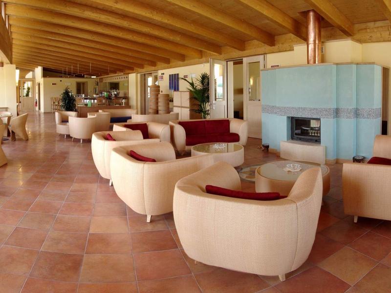 Spacious hotel lounge area with cream armchairs and wooden ceiling beams.
