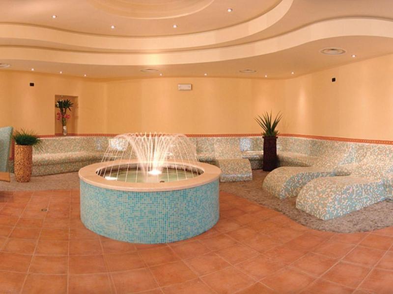 Relaxation area with curved seating, fountain, and warm lighting in hotel lounge.