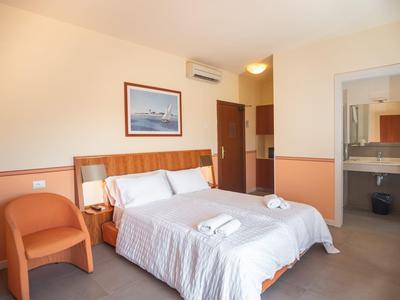 Habitación de hotel luminosa con cama doble, sillón y baño conectado visible