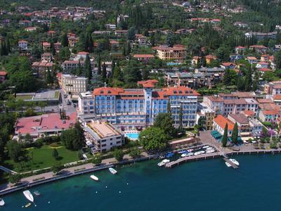 Vue d'un hôtel au bord de l'eau avec des bateaux et un paysage verdoyant en arrière-plan.