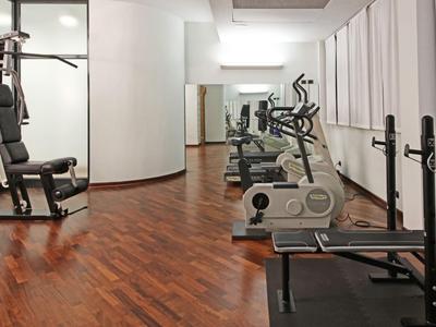 Modern gym with wooden flooring and various exercise equipment.