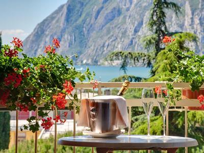 Tavolo con secchiello del ghiaccio su una terrazza con vista su un lago e montagne sullo sfondo