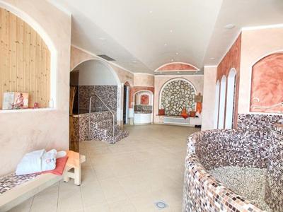 Intérieur d'un hôtel spa avec des détails en mosaïque et une chaise longue avec des serviettes.