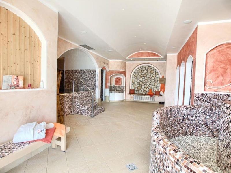 Intérieur d'un hôtel spa avec des détails en mosaïque et une chaise longue avec des serviettes.