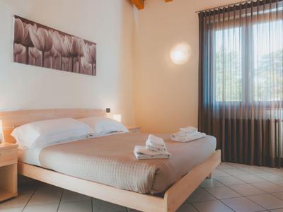 Jasno urządzone sypialnia z łóżkiem podwójnym i złożonymi ręcznikami na łóżku.