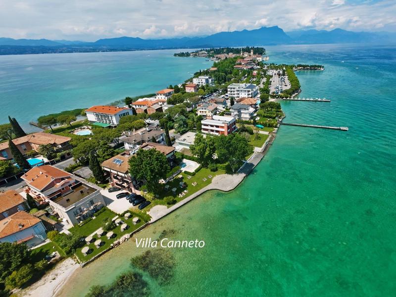 Letecký pohled na pobřežní město s čirou tyrkysovou vodou a budovami podél pobřeží.
