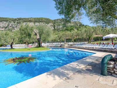 Piscina per il tempo libero con lettini e paesaggio verde sullo sfondo
