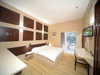 Modern eingerichtetes Schlafzimmer mit Doppelbett, Holzfußboden und großer Fensterfront.