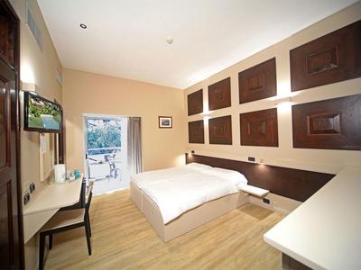 Modernes, helles Schlafzimmer mit Doppelbett, Schreibtisch, Stuhl und dekorativen Wandpaneelen.