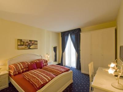 Chambre confortable avec lit double, commode, armoire et fenêtre avec rideaux.