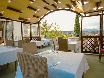 Gezellig terras met gedekte tafels en uitzicht op een groen landschap.