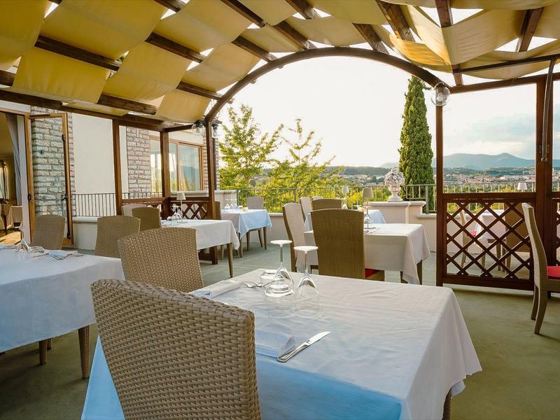 Gezellig terras met gedekte tafels en uitzicht op een groen landschap.