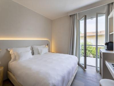 Dormitorio moderno con cama doble grande y balcón con vistas.