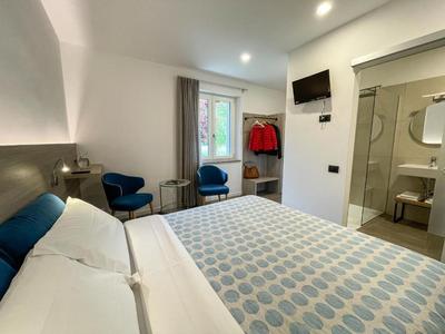 Modernes Hotelzimmer mit Doppelbett, Sitzecke und offenem Blick ins Badezimmer.