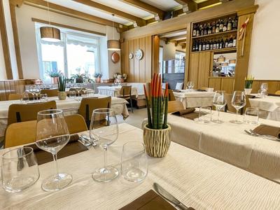 Gemütlicher Speiseraum in einem Hotel mit gedeckten Tischen und natürlichem Licht.