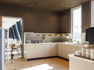 Modern eingerichteter Frühstücksbereich mit Theke und großzügigen Fenstern in einem Hotel.