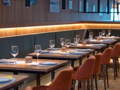 Modernes Restaurant mit elegant gedeckten Tischen und orangen Stühlen