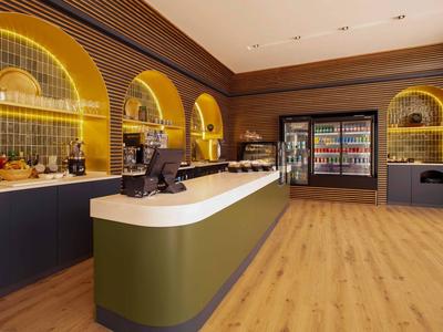 Moderne Hotelbar mit geschwungenem Tresen, Holzfußboden und beleuchteten Regalen.