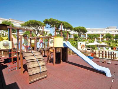 Kinderspielplatz mit Klettergerüst und Rutsche in Hotelanlage bei Sonnenschein
