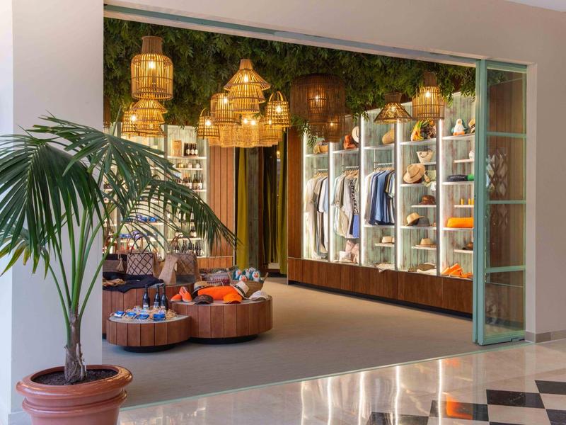 Gemütliche Hotel-Lobby mit Sitzgelegenheiten, Regalen und hängenden Laternen.