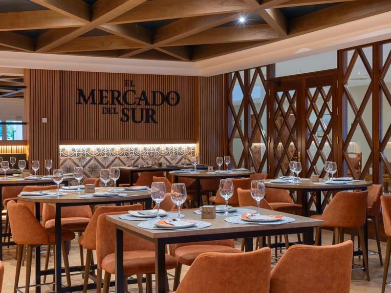 Modernes Restaurant mit Holzmöbeln, warmen Tönen und elegant gedeckten Tischen.