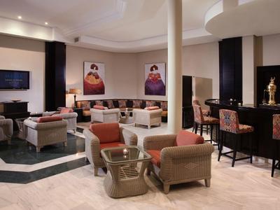 Moderne Lounge mit Sitzgruppen, Filzstühlen und Kunstwerken an den Wänden, helle Beleuchtung.