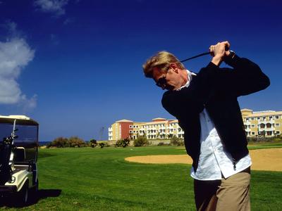 Leeres Strandrestaurant mit Stühlen und Tischen auf Holzterrasse am Meer bei Sonnenuntergang.