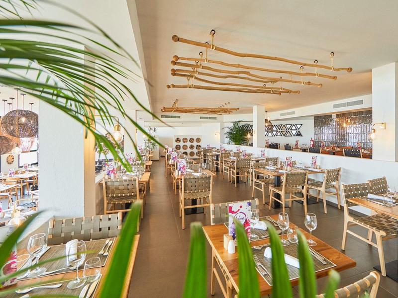 Hell beleuchteter Speisesaal mit modernen Holzbänken und dekorativen Pflanzen