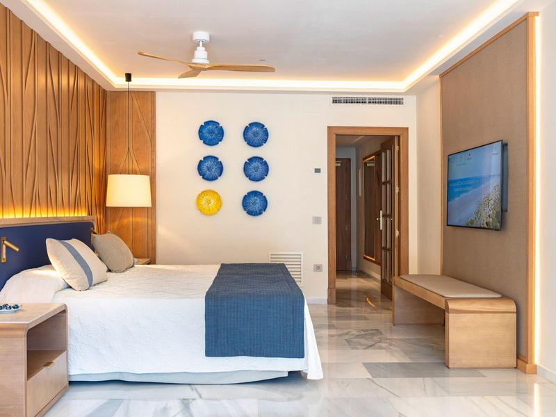 Modernes Schlafzimmer mit Doppelbett, blauen Akzenten und dekorativen Kreisen an der Wand.