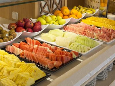 Buffet mit verschiedenen frischen Früchten und Melonenscheiben in einem Hotelrestaurant.