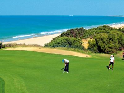 Moderner Innenraum mit Holzdecke, Glastrennwänden, Pflanzen und Figuren auf Brücke aus Beton.