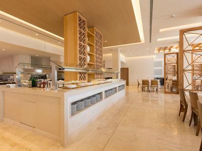 Helles Buffet und Essbereich mit Holzmöbeln in einem modernen Hotelrestaurant.