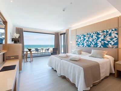 Modernes Hotelzimmer mit Doppelbett, Balkon und Meerblick bei Tageslicht