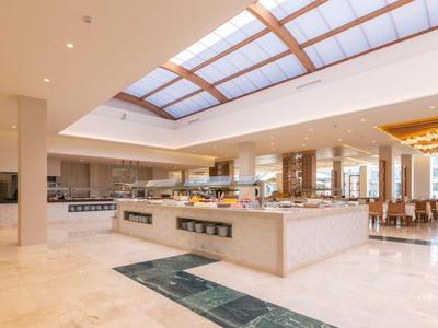 Helles, modernes Restaurant mit Buffetbereich und großen Fenstern für natürliches Licht.