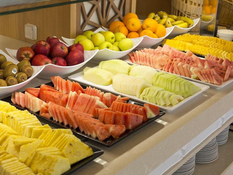 Buffet mit verschiedenen frischen Früchten und Melonenscheiben in einem Hotelrestaurant.