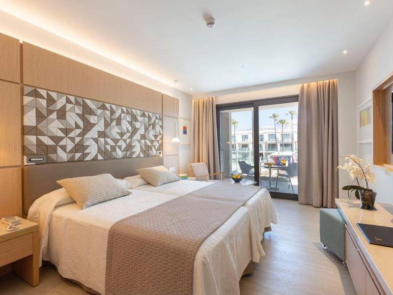 Helles Hotelzimmer mit zwei Einzelbetten, großem Fenster und modernem Interieur.