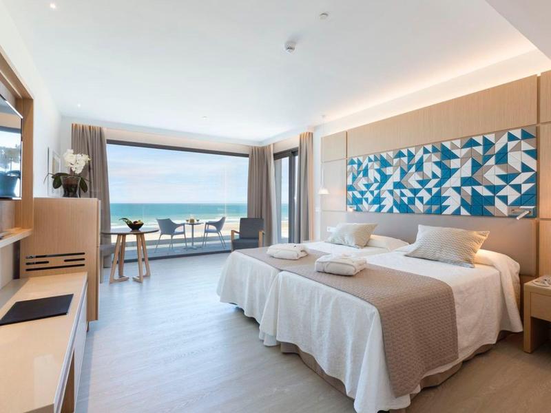 Modernes Hotelzimmer mit Doppelbett, Balkon und Meerblick bei Tageslicht